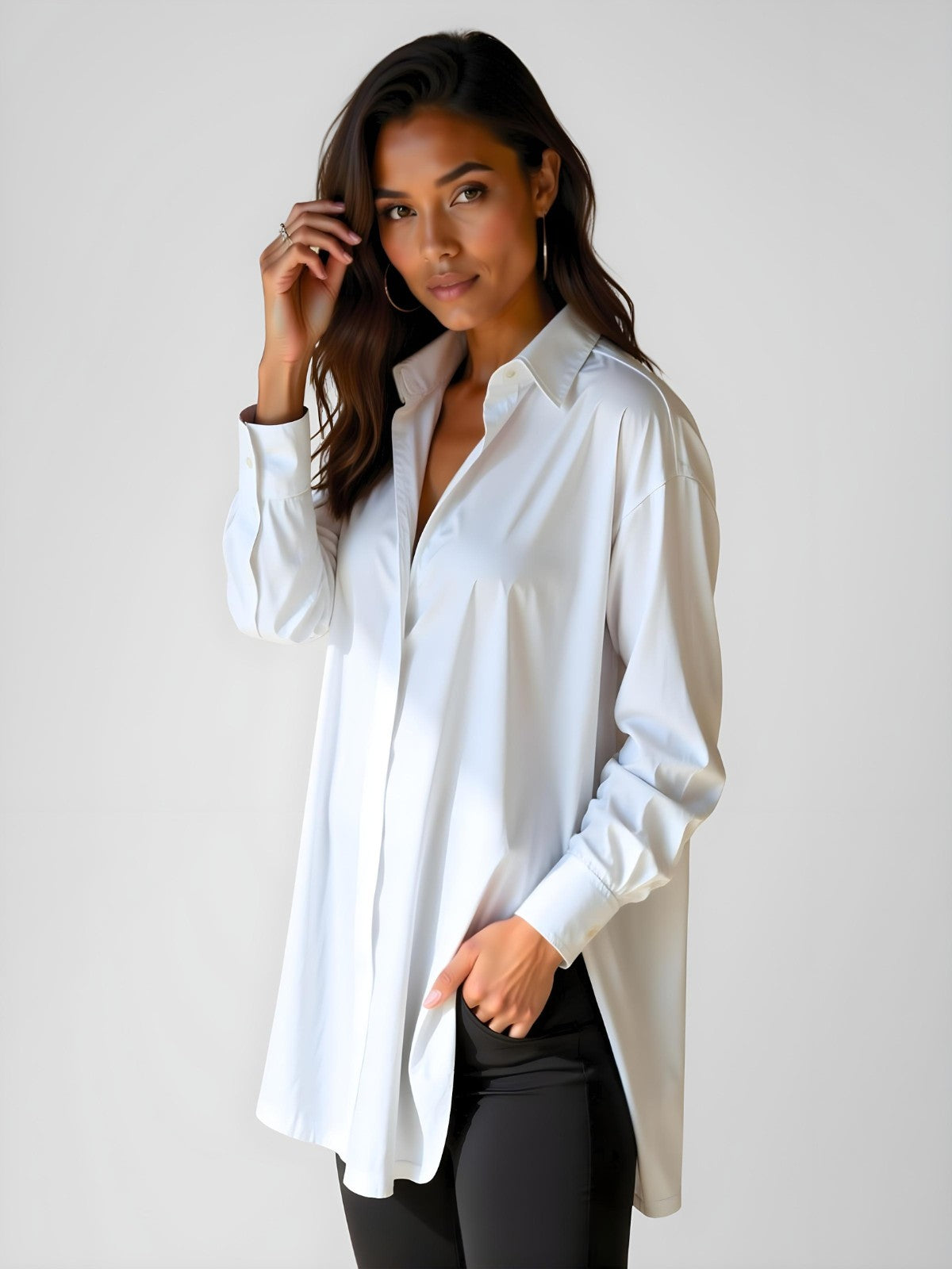 Woman wearing a white buttoned long shirt dress, standing and facing forward to show the fit and style.